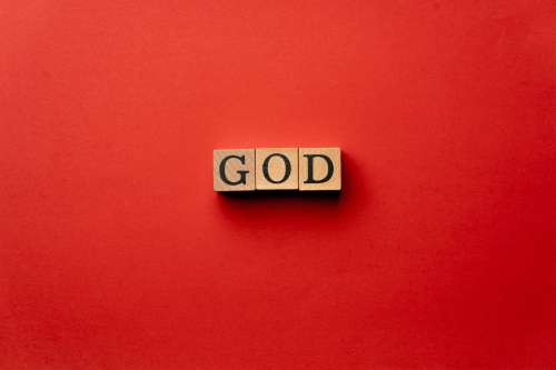 red warm background without shadows wooden cubes with black letters laid out word god